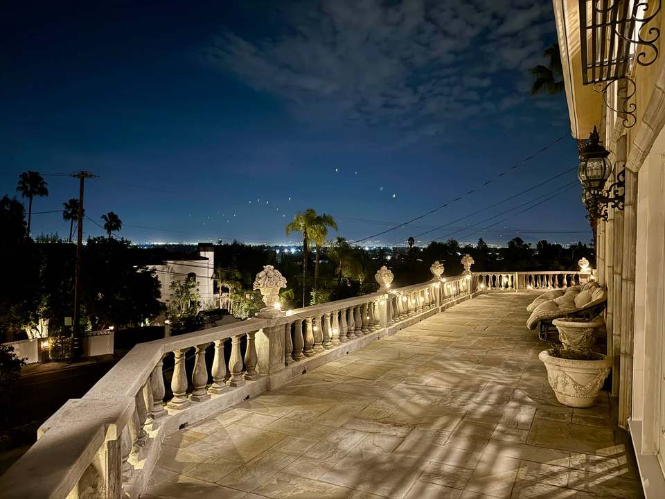 Front terrace at night with lit balustrades and the city lights of the Valley