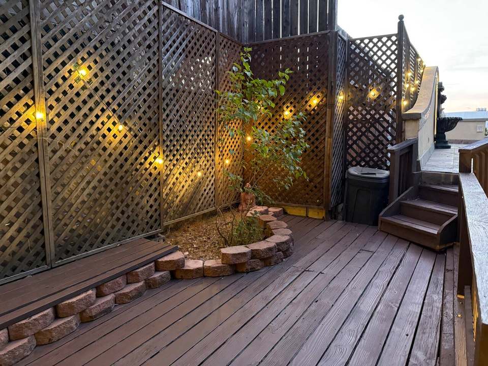 Deck garden corner with lattice screens and warm string lights